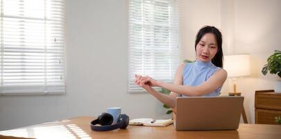 Asian college student sit at home studying online using a calling program on their laptop. photo