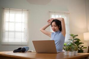 Asian college student who is bored Sitting in front of a laptop studying online through a calling program on a laptop at home. photo