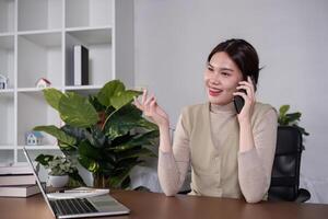 Asian college student sit at home studying online using a calling program on their laptop. photo