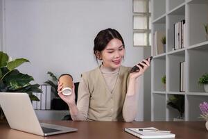 Asian college student sit at home studying online using a calling program on their laptop. photo