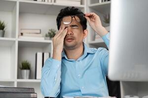 Tired professional struggles with hard work at office desk workspace stressful environment close-up view photo