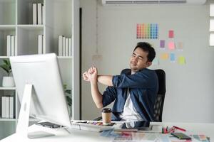 Young Designer Experiencing Pain While Working at Desk in Modern Office Environment with Computer and Creative Tools photo
