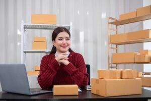 SME business entrepreneurs small in asia Write shipping information on a cardboard box in my home office. Small business operators preparing to ship to customers photo