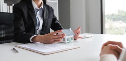 Couple Signing Real Estate Sales Contract in Modern Office Setting with Agent Present, Symbolizing New Home Purchase and Property Investment photo