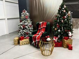 Cozy Christmas setting with trees, gifts, and a comfortable armchair photo