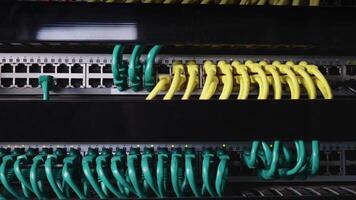 Neat and tidy patched network cables, RJ45, connected to the switches and routers mounted on the rack in data centre, networking video