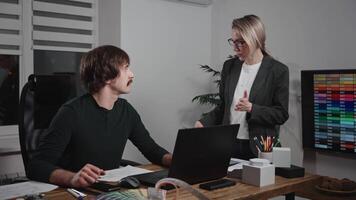 Design and architecture studio. A man and a woman are designers working with samples of materials and color palettes. Working on an apartment project. Laptop in frame video