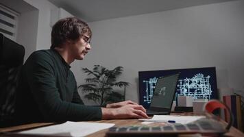Young design engineer working on laptop on house project. Architect designer in studio video