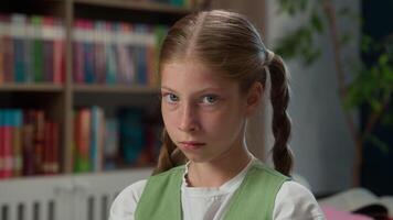 Sad upset Caucasian little child school girl kid depressed student schoolgirl unhappy learner bored pupil looking at camera studying problems education bullying learn trouble indoors library classroom video