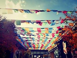 a street with many colorful flags hanging from the sky photo