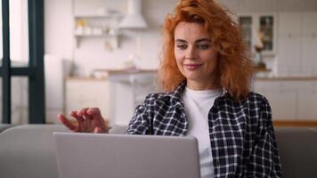 Smiling Caucasian woman on couch happy lady girl female chatting computer browsing surfing internet studying working online remote at home finish stop complete close laptop relax pause done resting video