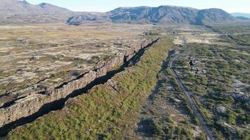 Icelandic Plate Fault. A large canyon with a mountain in the background. The canyon is very deep and the grass is green video