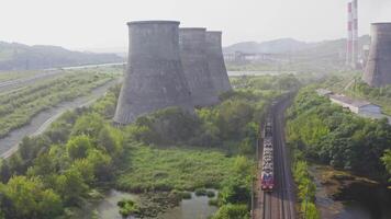 Drone view of a moving train and cooling towers video