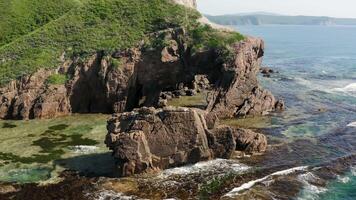 Drone view of a natural stone arch on the seashore on a sunny day video