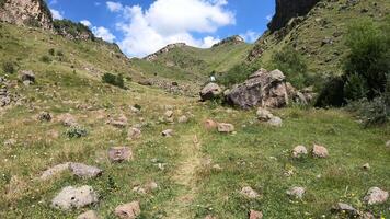 Trekking in the Caucasus Mountains along a mountain path up video