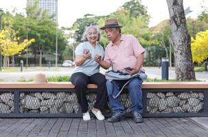 Asian senior couple traveler enjoying trip and vacation in downtown, Senior couple using smartphone photo