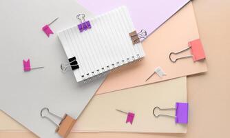 Paper clips and notepads on a beige background photo