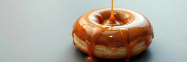 Delicious donut topped with rich caramel sauce drizzled over its smooth glaze in a cozy setting photo