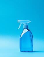 Blue cleaning spray bottle on blue background with white trigger sprayer photo