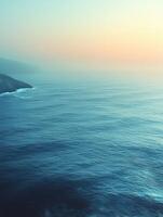 Calm ocean reflecting beautiful sunset colors during twilight photo