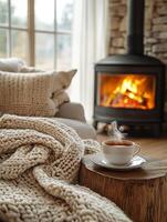 Warm tea near fireplace and cozy blanket photo