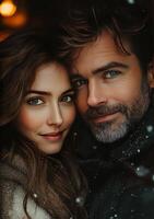 Romantic couple embracing under gently falling snowflakes photo