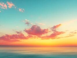 Pink clouds drifting across a turquoise sky at sunset over calm ocean photo