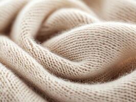 Beige knitted wool fabric forming soft folds, warm and cozy background photo