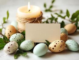 Easter eggs, candle and blank greeting card decorating a white photo
