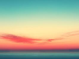Pink clouds across a turquoise sky at sunset over calm ocean photo