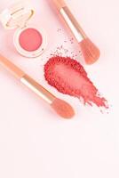 An open round pack of pink blush, a beautiful sample of dry blush, two makeup brushes on a light vertical background. top view. A copy space. Makeup. photo