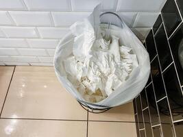 Bathroom trashcan filled with used tissues is not related to food, recipe, ingredient, kitchen appliance, cuisine, dish, dairy, cream, buttercream, or major appliance. photo