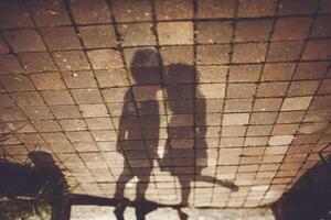 Two shadows on brick floor create symmetry and pattern photo