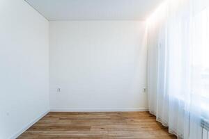 A minimalist room with wooden floor and sheer curtains, clean lines and modern design creates a tranquil and uncluttered interior with a bright, serene atmosphere photo