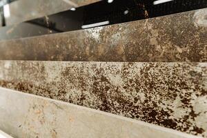 The photograph displays various stains on a marble countertop, possibly from substances such as automotive tires, wood, and asphalt, creating a detailed view of the damage photo