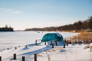 A greenhouse is situated in the center of a snowcovered field, surrounded by a vast expanse of white, sparkling snow that blankets the ground, typical of winters cold embrace photo