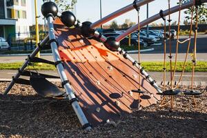 This lively and vibrant playground serves as a delightful haven for children, featuring a sturdy wooden slide, robust climbing ropes, and ample space for adventurous and imaginative play photo