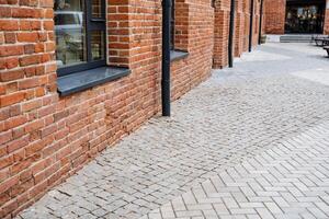 A tall and majestic brick building impressively stands out in its surroundings, beautifully enhanced by a charming walkway that effortlessly draws the eye of every passerby who walks by photo