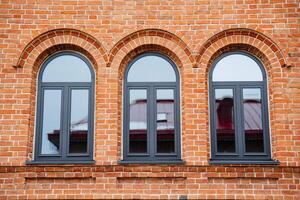 The striking red brick building features three elegantly arched windows, enhancing its architectural style and contributing to its stunning visual appeal and unique character photo