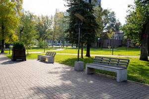There is a beautiful park that features a charming bench located right in the center of it, surrounded by vibrant grass, lush trees, and a natural landscape that invites relaxation photo