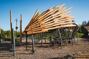 In a vibrant playground, children can explore a sturdy wooden structure along with a high slide, creating a secure and enjoyable environment for various outdoor activities and play photo