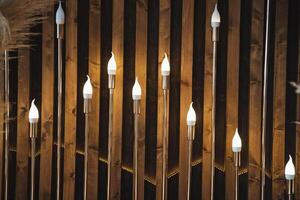 A beautifully crafted wooden wall adorned with bright, twinkling lights creates a warm and inviting atmosphere, significantly enhancing the charm and aesthetic appeal of the entire space photo