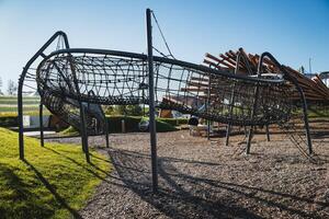 A lively playground featuring a fun slide as well as an exciting ropes course situated in a beautiful park that is ideal for recreational activities and leisure time enjoyment photo