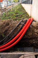 A collection of bright red pipes lies in the dirt, waiting to be used for an upcoming construction or renovation project, highlighting their role in infrastructure development photo