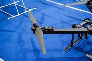 A small drone is positioned gently on a soft blue carpet, creating a striking and intriguing contrast that captures and captivates the eye in a warm and inviting indoor setting photo