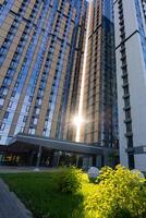 The sun is brilliantly shining through the large windows of a tall building, illuminating the space inside and casting beautiful patterns across the floors and furniture photo