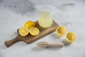 lemon juice on a wooden board with a knife and a lemon photo