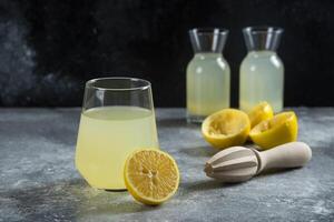 A cup of lemonade with slices of lemon and wooden reamer photo