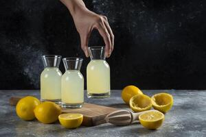 A hand taking a jar of lemon juice photo
