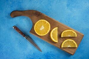 Sliced orange with knife on a wooden board photo